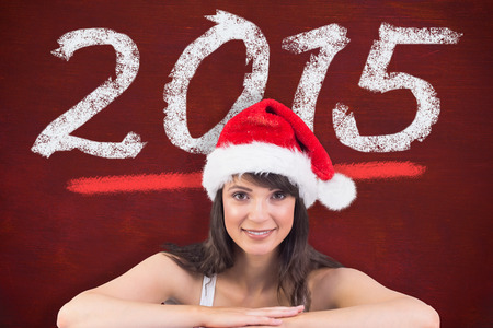 Festive brunette leaning on large poster against desk