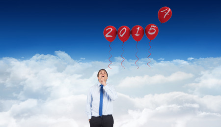 Thinking businessman touching his chin against bright blue sky over clouds