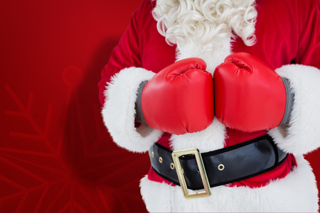 Mid section of santa with boxing gloves against red snowflake backgroundの写真素材