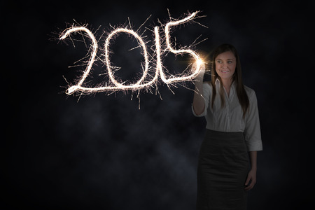 Businesswoman touching spark against dark background