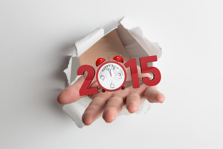 Hand bursting through paper against 2015 with alarm clockの写真素材