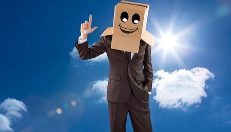 Anonymous businessman pointing up with finger against bright blue sky with clouds