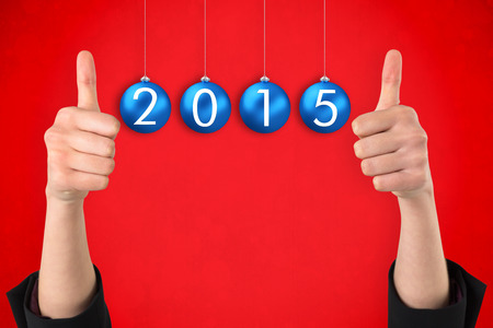Businesswomans hands showing thumbs up against red background