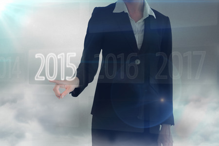 Businesswoman pointing somewhere against 2015 on interfaceの写真素材
