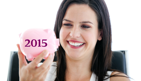 Laughing businesswoman holding a piggybank  against 2015 in greyの写真素材