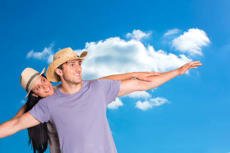 Man giving his pretty girlfriend a piggy back against cloudy skyの写真素材