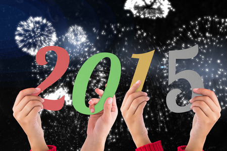 Hands holding poster against white fireworks exploding on black background