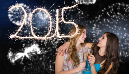 Friends drinking champagne against white fireworks exploding on black background