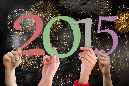 Hands holding poster against colourful fireworks exploding on black background