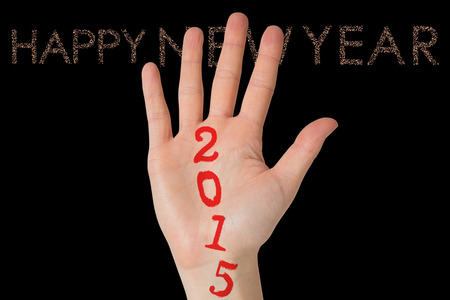 Hand with fingers spread out against glittering happy new yearの写真素材