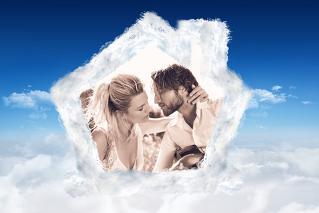 Handsome man serenading his girlfriend with guitar against bright blue sky over cloudsの写真素材