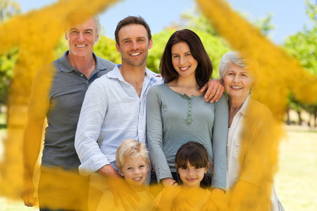 Family standing in the park against house outline in clouds