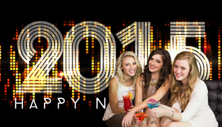 Friends drinking cocktails  against 2015 in colourful lightsの写真素材