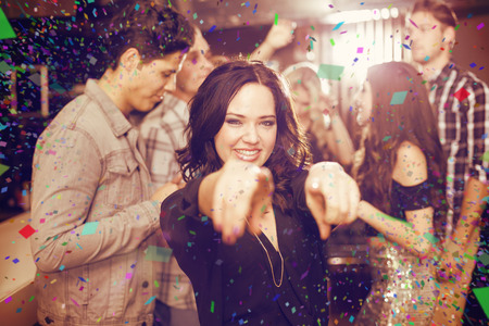 Stylish brunette smiling and dancing against flying colours