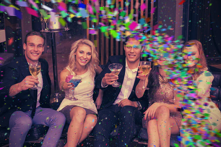 Happy friends having a drink together against colour curve