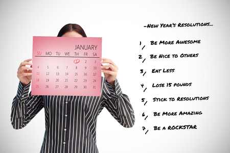 Businesswoman showing a calendar in front of her face against pink card