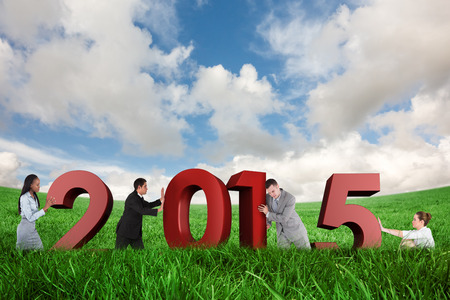 Portrait of a handsome businessman pushing a wall against green field under blue sky