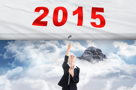 Businesswoman pulling a chain against mountain peak through the cloudsの写真素材