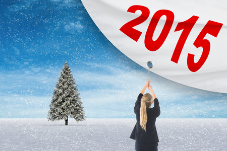 Businesswoman pulling a chain against snowy landscape with fir trees