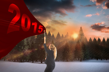 Businesswoman pulling a chain against fir tree forest in snowy landscapeの写真素材