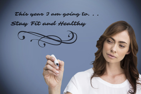 Concentrated businesswoman holding whiteboard marker against grey vignette