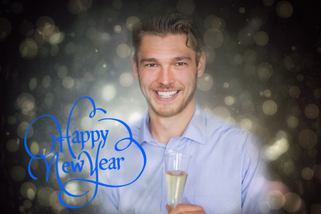 Man toasting with champagne against black abstract light spot designの写真素材