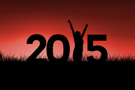 Cheering female silhouette against red sky over grassの写真素材