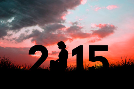 Female silhouette against red sky over grassの写真素材