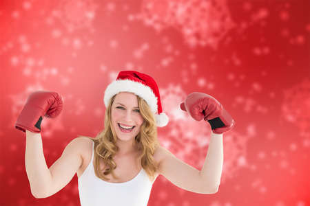 Festive blonde with boxing gloves against digitally generated delicate snowflake designの写真素材