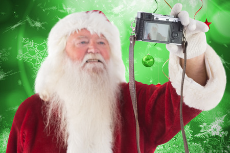 Santa Claus makes a selfie against hanging christmas decorationsの写真素材