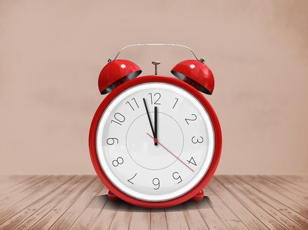 Alarm clock counting down to twelve against room with wooden floorの写真素材
