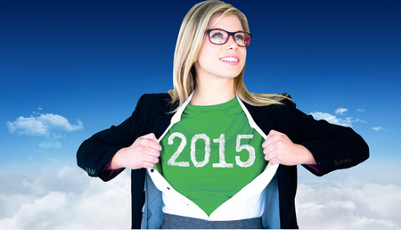 Businesswoman opening shirt in superhero style against bright blue sky over clouds
