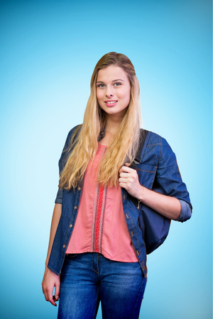 Pretty student in the library against blue background with vignetteの写真素材
