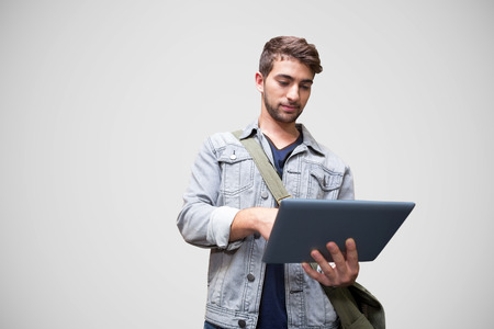 Student using tablet in library  against grey vignette