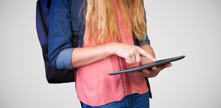 Student using tablet in library  against grey vignetteの写真素材