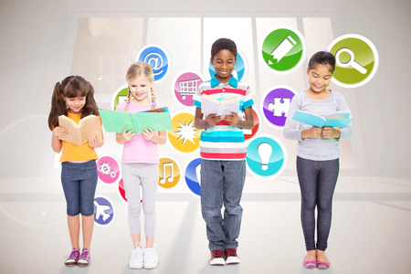 Elementary pupils reading against computing application iconsの写真素材