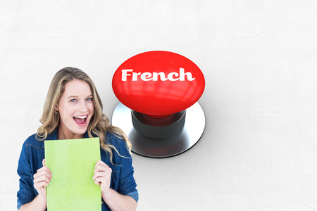 The word french and smiling student holding notebook against digitally generated red push button