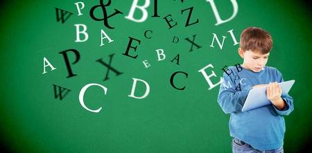 Cute boy using tablet against greenの写真素材