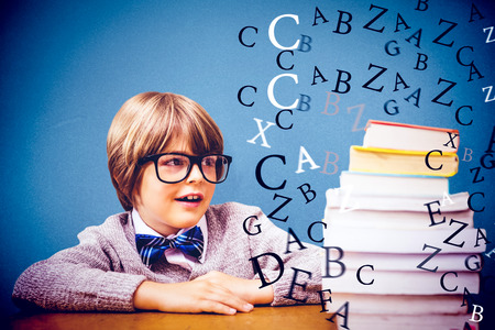 Cute pupil with pile of books against blue backgroundの写真素材