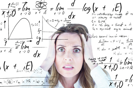 Stressed businesswoman with hands on her head against maths equationの写真素材