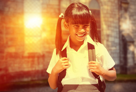 School kid against grey school buildingの写真素材