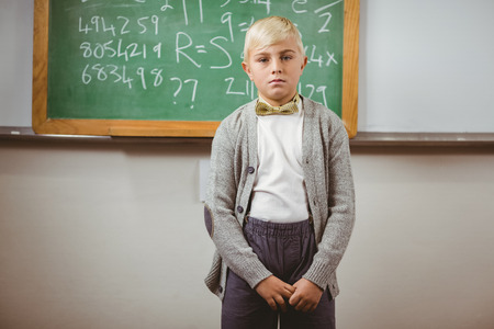 Portrait of pupil dressed up as teacher in front of chalkboard in a classroomの写真素材