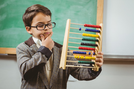 Pupil dressed up as teacher holding abacus in a classroomの写真素材