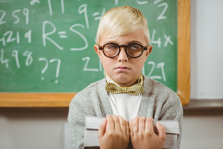 Pupil dressed up as teacher holding books in a classroomの写真素材
