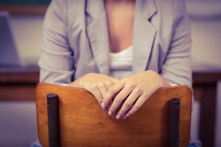 Teacher sitting on chair in a classroom in schoolの写真素材