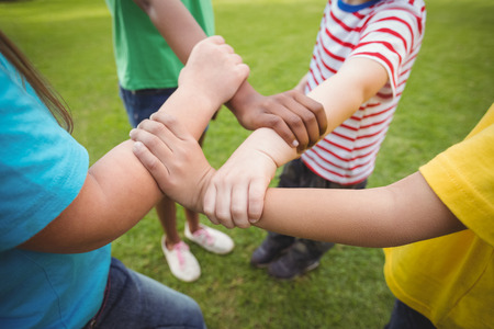 Diverse classmates holding arms on campusの写真素材