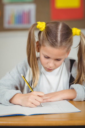 Concentrated pupil working at her desk in a classroom in schoolの写真素材