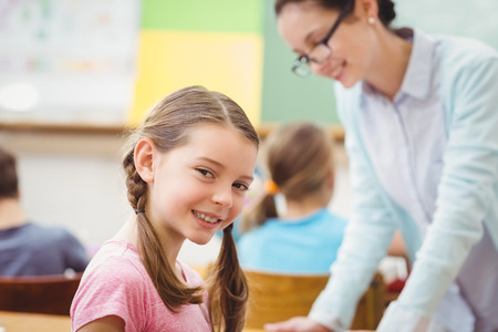 Teacher helping a pupil during class at the elementary schoolの写真素材