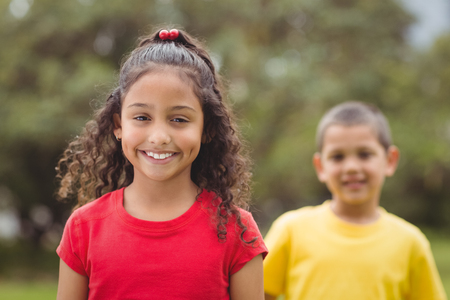 Cute pupils smiling at camera outside on elementary school campus