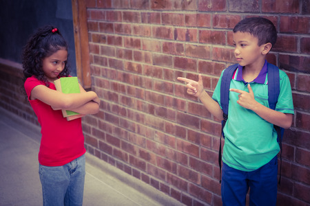 Upset child being teased by another child on the elementary school grounds